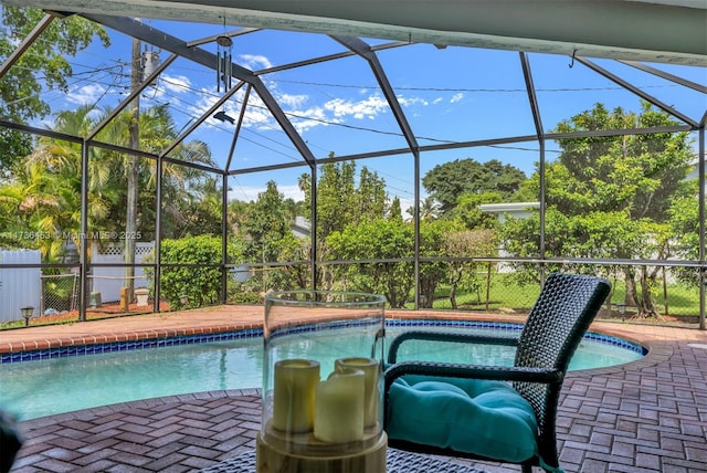 view of pool with a patio area and glass enclosure