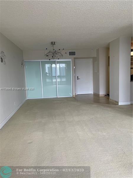 spare room with carpet flooring and a textured ceiling