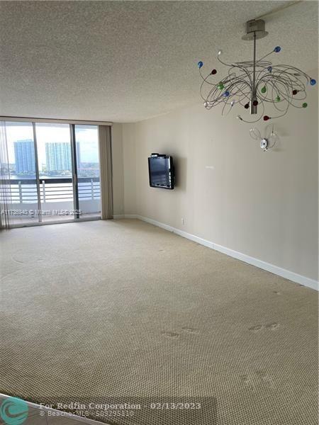 spare room with floor to ceiling windows, a textured ceiling, and carpet