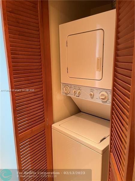 clothes washing area featuring stacked washer / drying machine