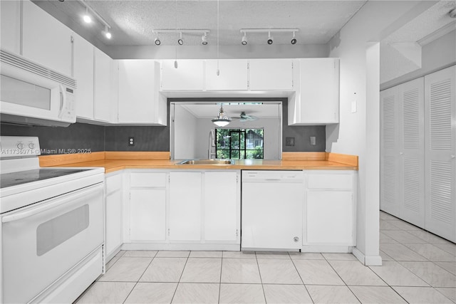 kitchen with white cabinetry, sink, a textured ceiling, and white appliances