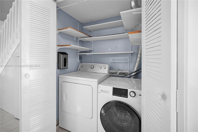 laundry area featuring washer and dryer and a textured ceiling