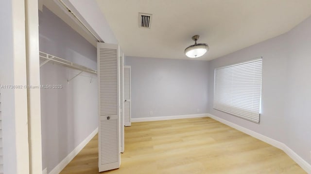 unfurnished bedroom featuring hardwood / wood-style floors and a closet