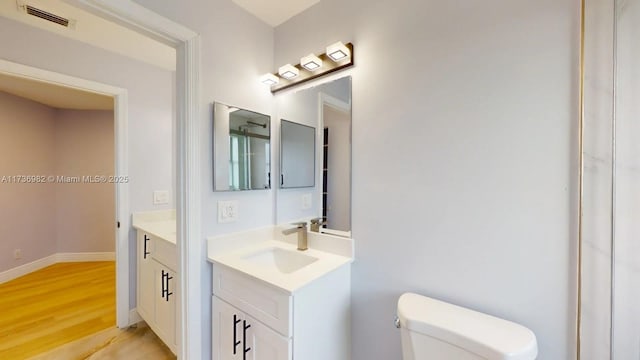 bathroom featuring vanity, hardwood / wood-style floors, and toilet