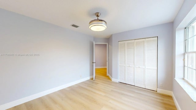 unfurnished bedroom featuring light wood-type flooring and a closet