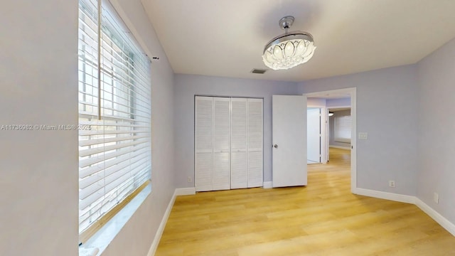 unfurnished bedroom featuring light wood-type flooring and a closet