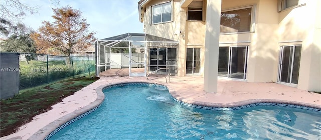 view of swimming pool featuring glass enclosure and a patio area