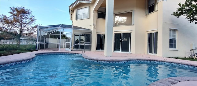 view of pool featuring a patio and glass enclosure