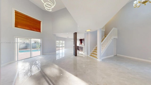 unfurnished living room with a towering ceiling and a notable chandelier