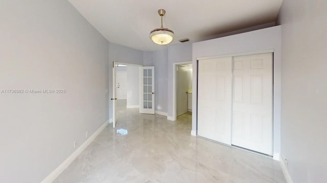 unfurnished bedroom featuring french doors and a closet