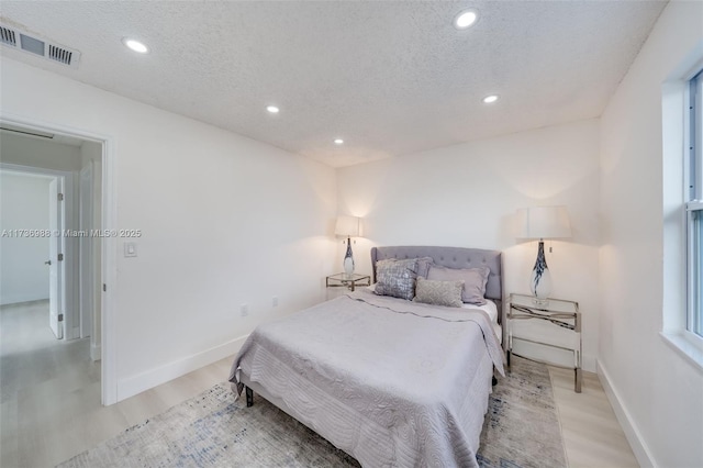 bedroom featuring a textured ceiling and light wood-type flooring