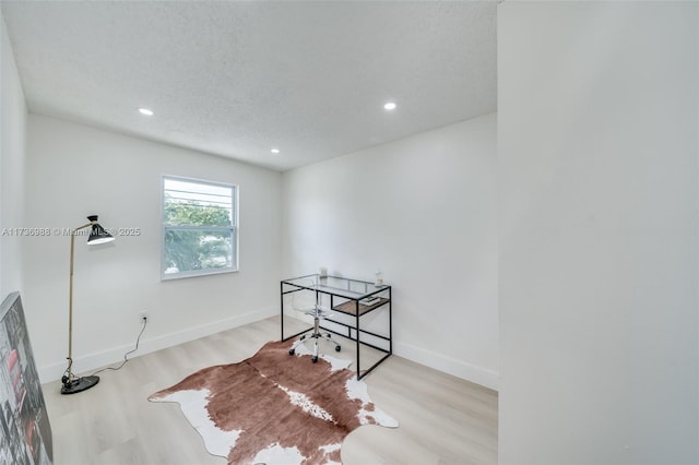 interior space featuring light hardwood / wood-style floors and a textured ceiling