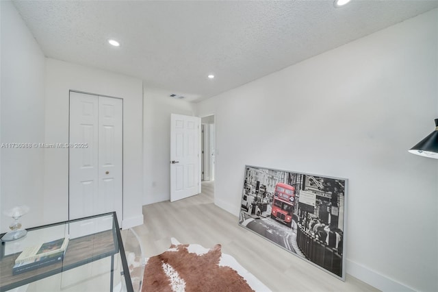 interior space with light hardwood / wood-style floors and a textured ceiling