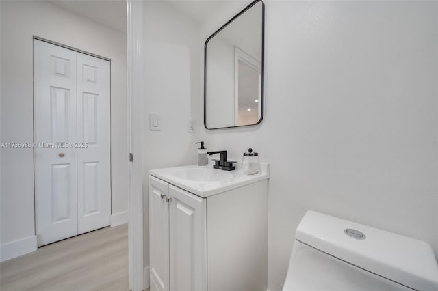 bathroom featuring vanity, hardwood / wood-style floors, and toilet