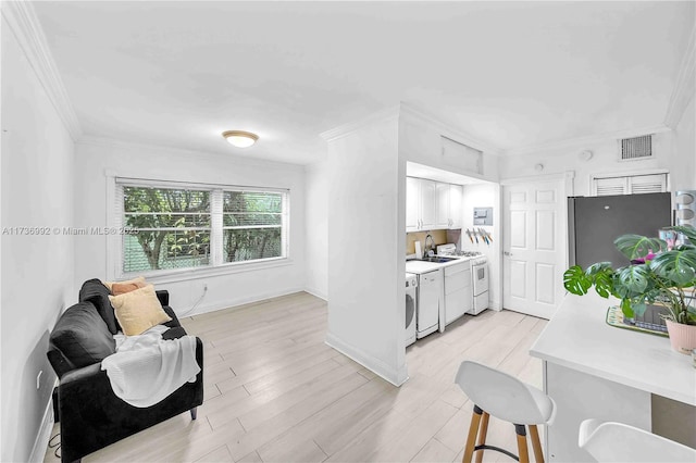 kitchen with white cabinetry, white appliances, crown molding, and light wood-type flooring