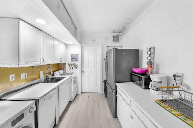 kitchen with sink, crown molding, appliances with stainless steel finishes, white cabinetry, and washer / dryer