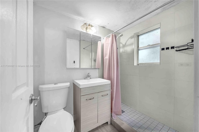 bathroom with walk in shower, vanity, and toilet