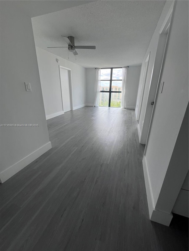 spare room featuring ceiling fan, dark hardwood / wood-style floors, and a textured ceiling