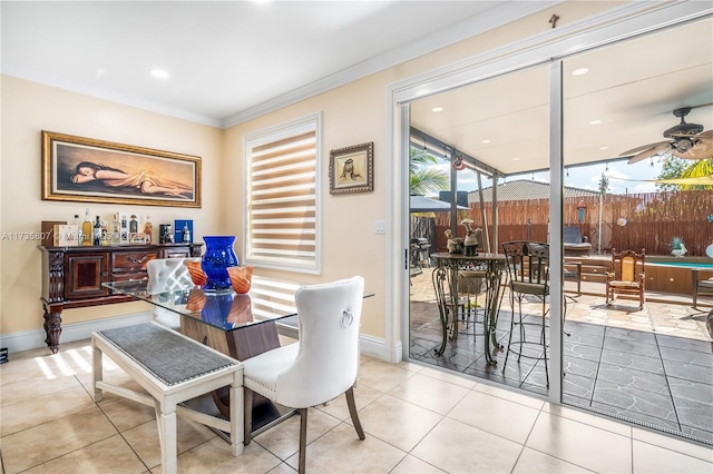 tiled dining space with crown molding and ceiling fan