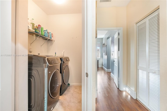 laundry area featuring washer and dryer and light tile patterned flooring