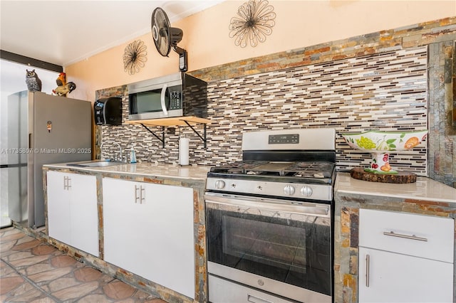 kitchen featuring white cabinetry, appliances with stainless steel finishes, sink, and backsplash