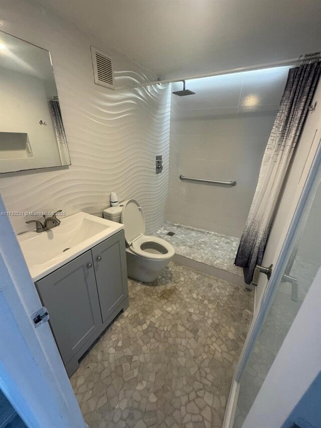 bathroom with vanity, curtained shower, and toilet