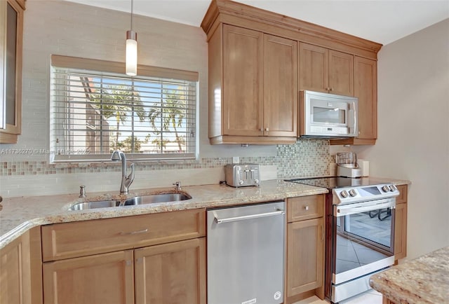 kitchen featuring pendant lighting, sink, stainless steel appliances, light stone counters, and decorative backsplash