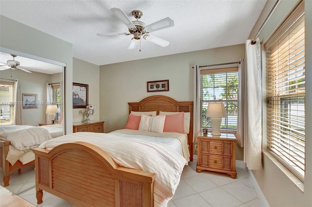 tiled bedroom featuring ceiling fan and a textured ceiling