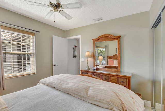 bedroom with ceiling fan, a closet, and a textured ceiling