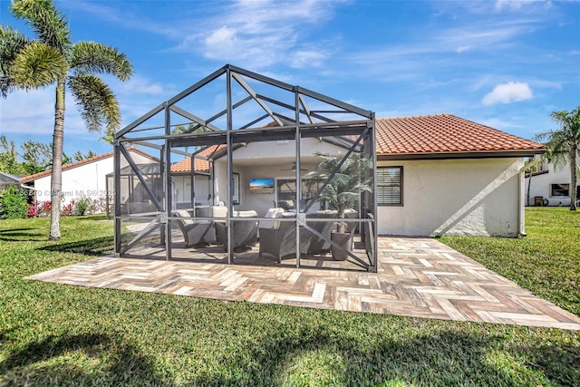 back of property with a lanai, a lawn, and a patio