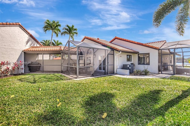 back of property with a lanai, a lawn, and a patio