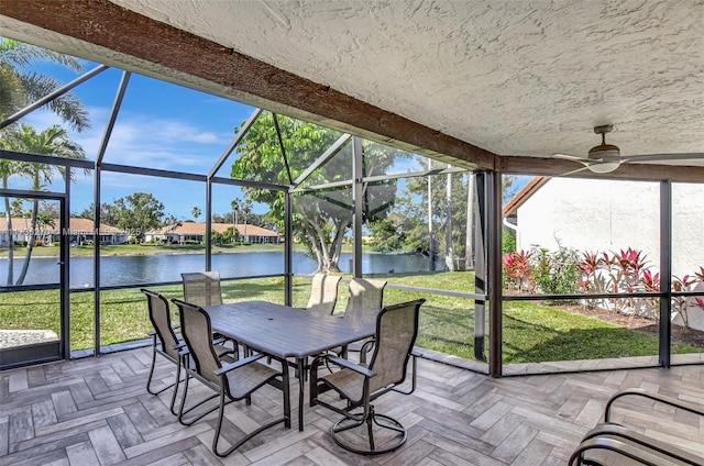 sunroom / solarium with a water view and ceiling fan