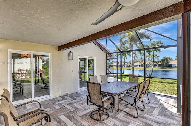 sunroom with vaulted ceiling with beams and a water view