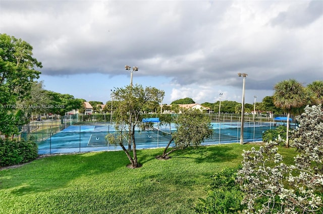 view of tennis court featuring a lawn