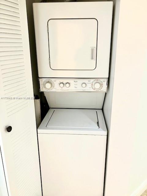 washroom featuring stacked washer and clothes dryer