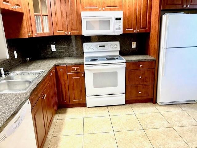 kitchen featuring tasteful backsplash, sink, white appliances, and light tile patterned flooring