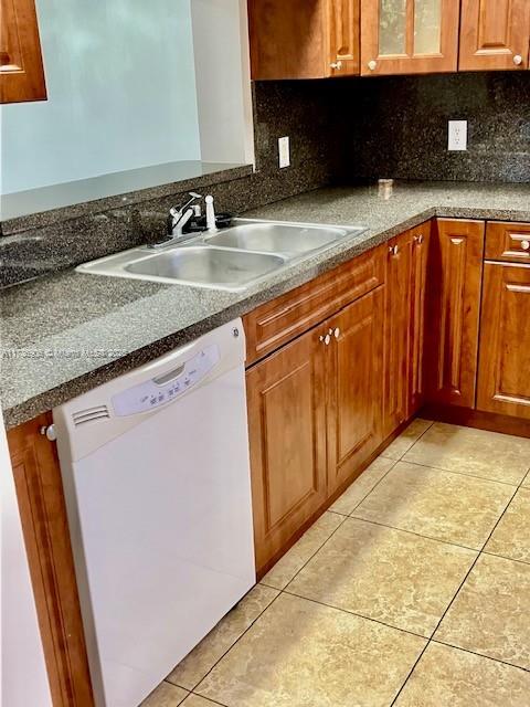 kitchen with sink, light tile patterned floors, dishwasher, and backsplash