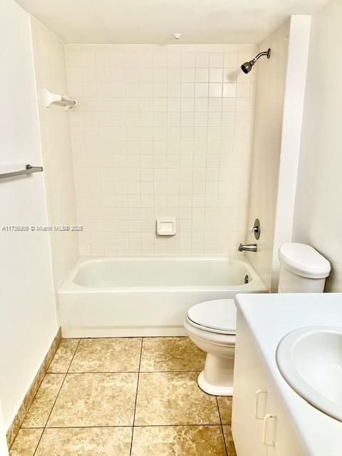 full bathroom featuring tile patterned floors, vanity, toilet, and tiled shower / bath combo