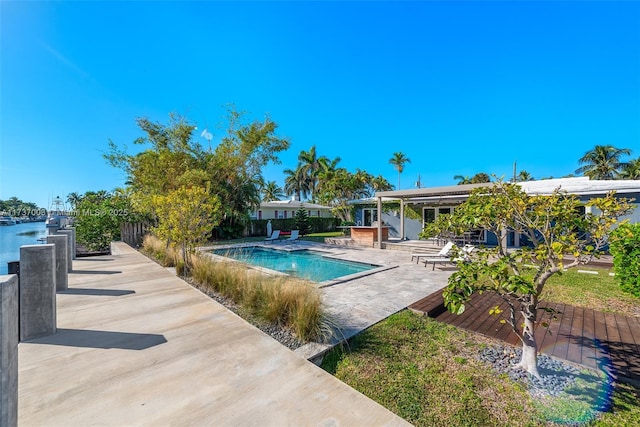 view of pool with a patio and a water view