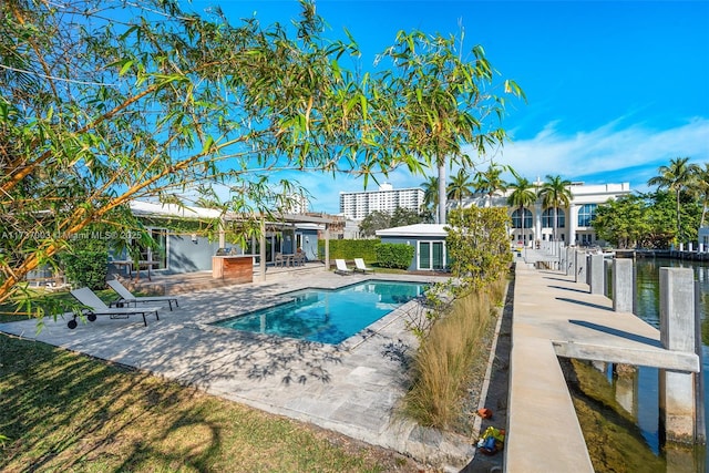 view of pool with a water view and a patio area