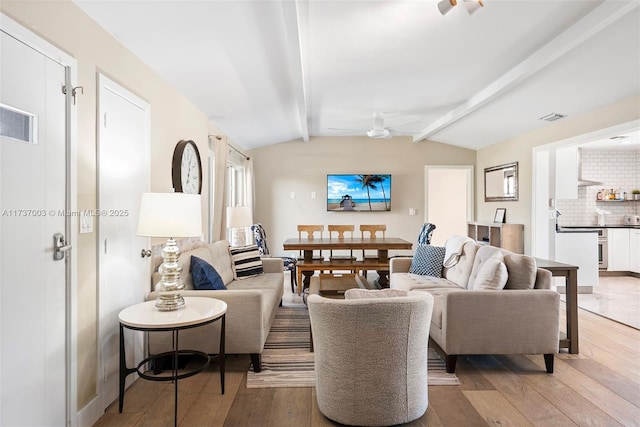 living room featuring lofted ceiling with beams, hardwood / wood-style floors, and ceiling fan