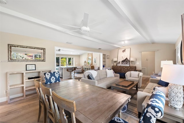 dining area with ceiling fan, light wood-type flooring, and vaulted ceiling with beams