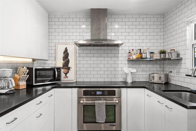 kitchen featuring sink, white cabinetry, stainless steel appliances, decorative backsplash, and exhaust hood