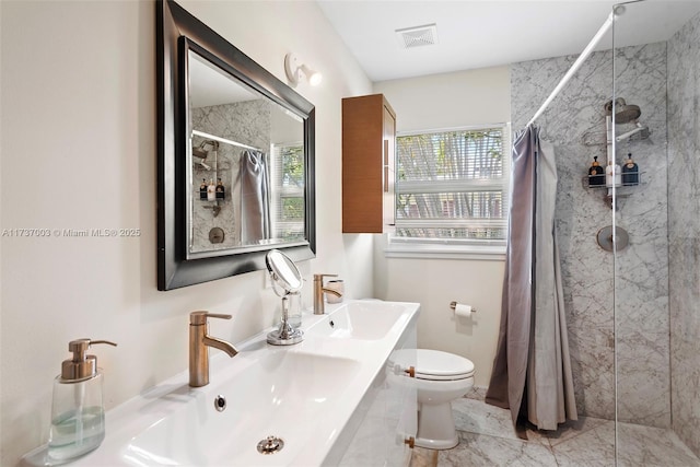 bathroom featuring toilet, sink, and a wealth of natural light