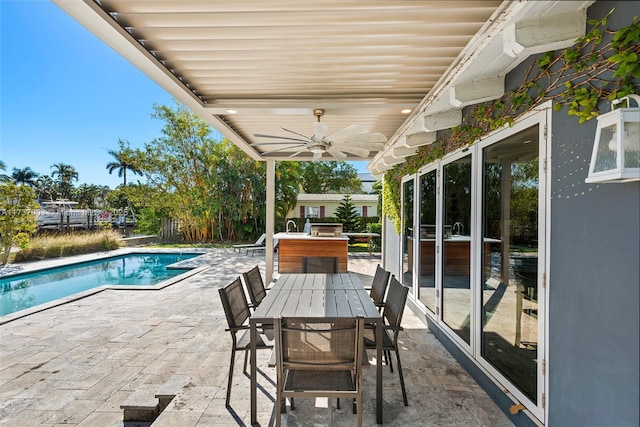 view of pool with exterior bar, ceiling fan, and a patio area