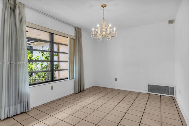 spare room featuring an inviting chandelier and light tile patterned flooring