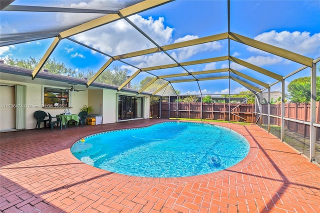 view of pool with glass enclosure and a patio area