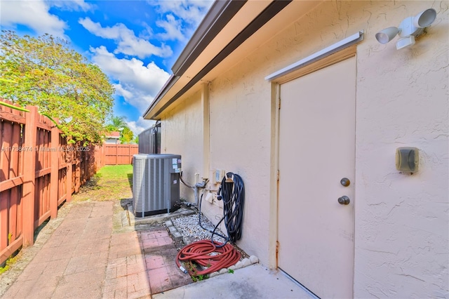 entrance to property featuring a patio area and central air condition unit