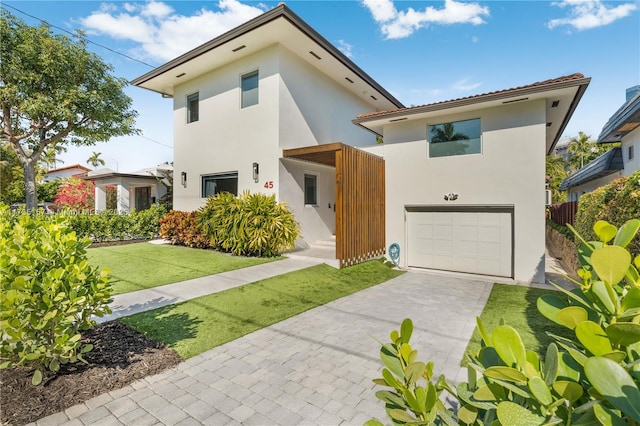 view of front of property with a garage and a front lawn