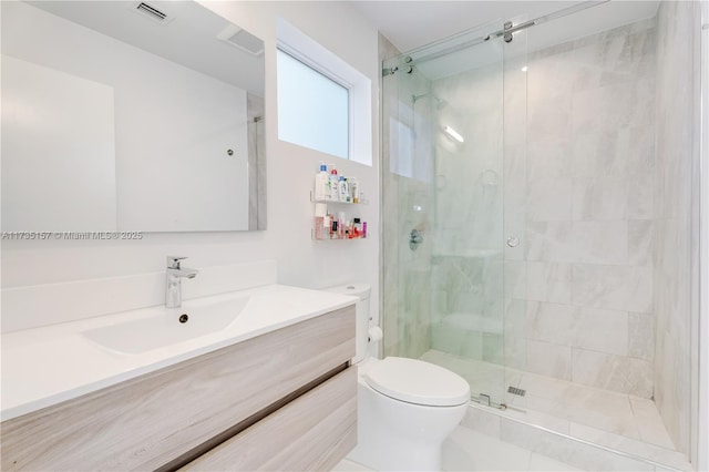 bathroom with vanity, toilet, and a shower with door